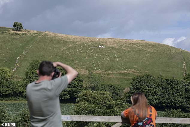 Volunteers and staff restore 180-foot Cerne Abbas Giant with 17 tonnes of chalk.